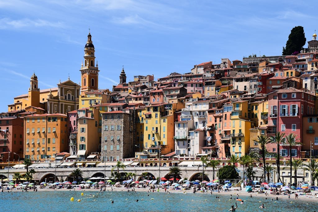 Vibrant buildings overlooking a lively beach in sunny Menton, Provence-Alpes-Côte d'Azur.